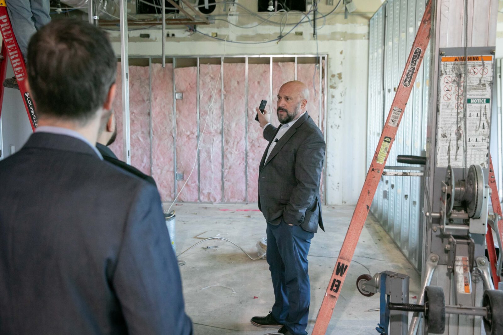 Photo of Brian Koegle giving a tour of Koegle Law Groups office under construction in Santa Clarita highlighting the firms growth and upcoming brick and mortar space