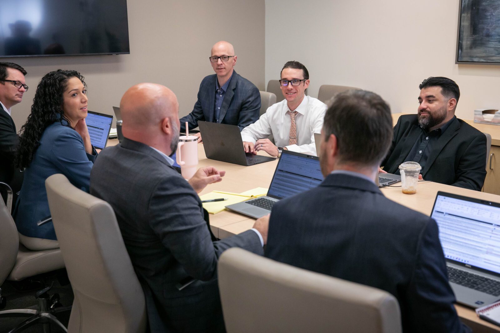 Photo of the Koegle Law Group team in a conference room meeting with attorneys and staff collaborating around a table during a planning session led by Brian Koegle